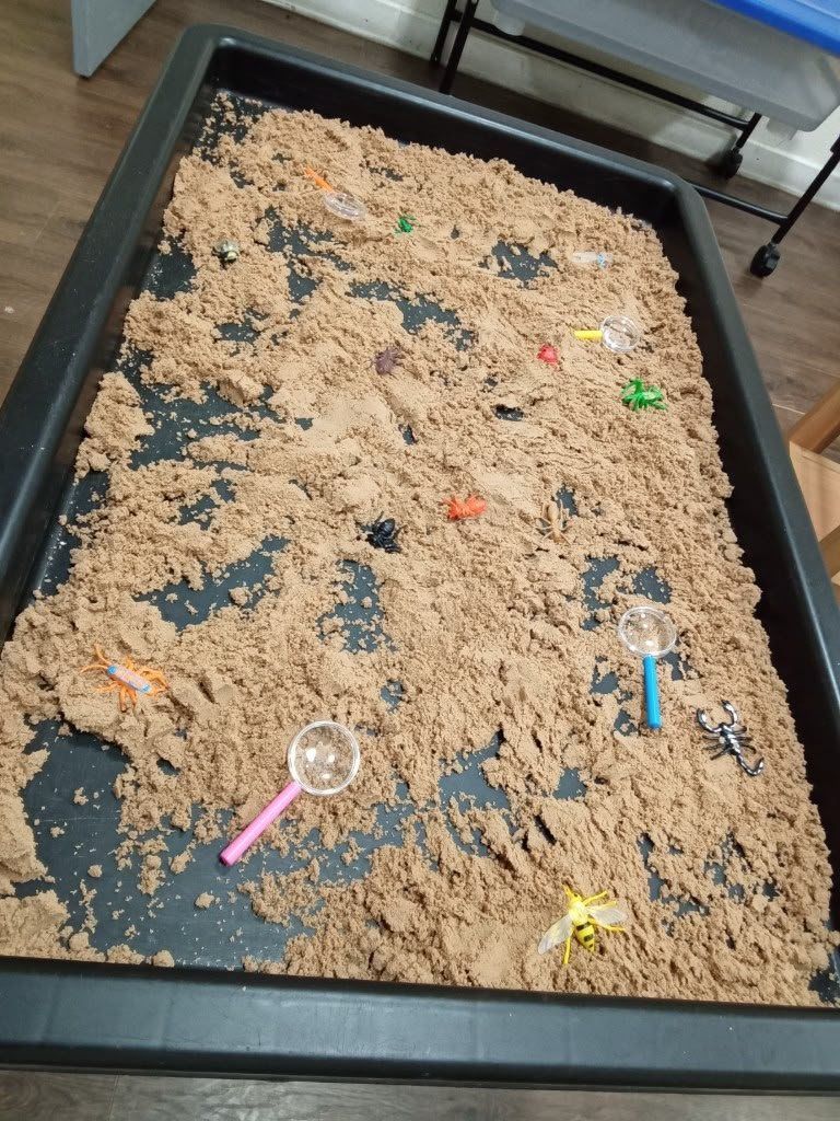 A large sand tray for messy, hands-on exploration