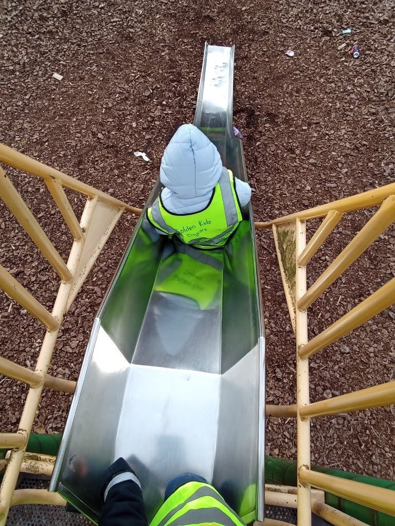 A child heading down the slide at the park